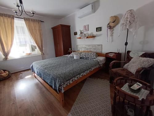 a bedroom with a bed and a couch and a chair at Tisza-tavi Menedék in Poroszló