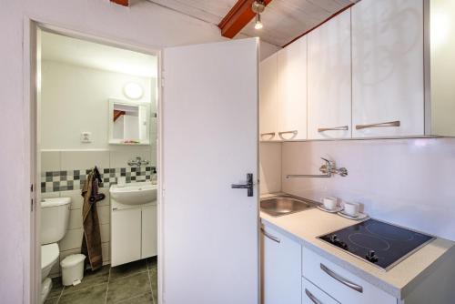 a kitchen with white cabinets and a sink at Pension Elbrs in Mariánské Lázně