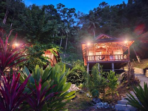 a tree house in the jungle at night at Banua Guesthouse in Pulau Malenge