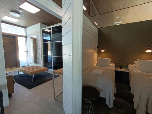 a room with two beds and a glass wall at Luksushuvila yksityisellä SPA-alueella ja järvinäköalalla in Ähtäri