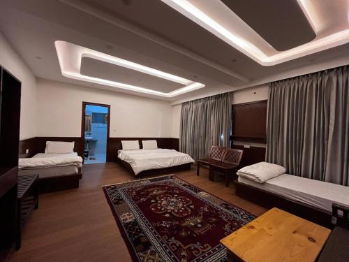 a living room with two beds and a rug at Teyser Holiday Home in Leh
