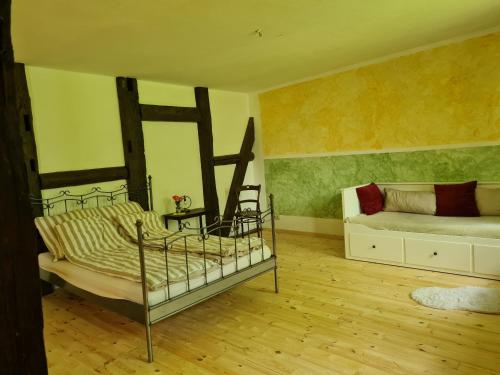 a bedroom with a bed and a couch in it at Große Ferienwohnung 160qm in einzigartigem historischen 700 Jahre altem Gebäude in Hardegsen