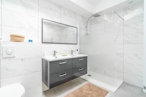 a white bathroom with a sink and a mirror at Secret Garden in Vias