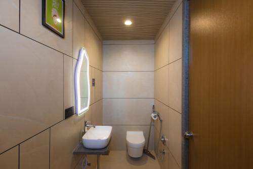 a bathroom with a toilet and a sink at Nirrtul Crystal 1BHK Apartment Cozy & Quite in Surat