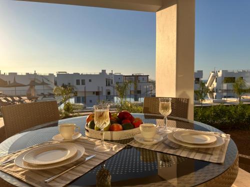 a table with a bowl of fruit and wine glasses at Mykonos Homes Cyprus in Kyrenia