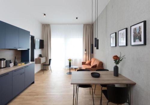 a kitchen and living room with a table and a living room at Brera Serviced Apartments Singen in Singen