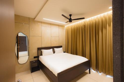 a bedroom with a bed and a ceiling fan at Nirrtul Crystal 1BHK Apartment Cozy & Quite in Surat
