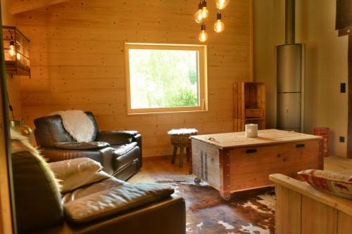 a living room with leather furniture and a window at Chalet Rustifol in Orsières