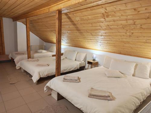 a room with three beds and a wooden ceiling at Cabana Tarța din Blidari 1 in Baia Mare