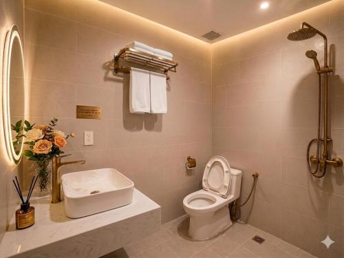 a bathroom with a toilet and a sink at Bareka Hotel in Phú Quốc