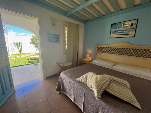 a bedroom with a bed and a door to a patio at Albergo isola mia in Favignana
