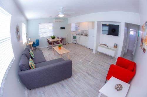 a living room with a couch and a red chair at St. Pete Beach Suites in St Pete Beach