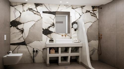 a bathroom with a sink and a mirror at Terracotta Sunset Suites in Oia