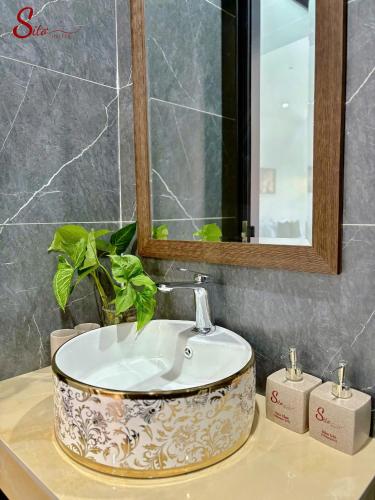a sink in a bathroom with a mirror and a plant at New Sitơ Hotel in Quảng Ngãi