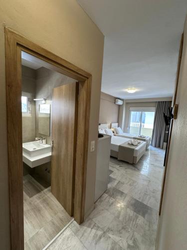 a bathroom with a sink and a bed in a room at Olympic Beach Rooms in Olympic Beach