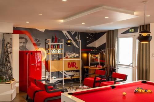 a room with a pool table and red chairs at Hôtel Gustave Colmar in Colmar