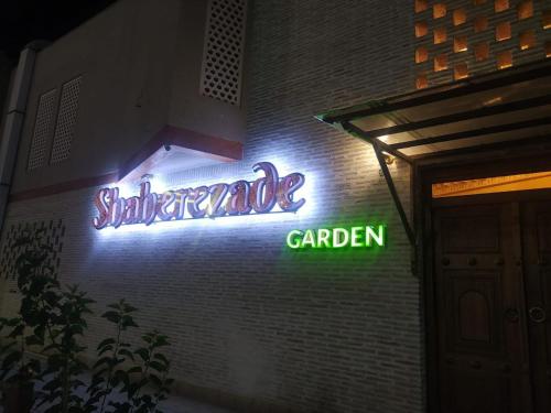 a neon sign on the side of a building at The Garden of Shaherezade in Bukhara
