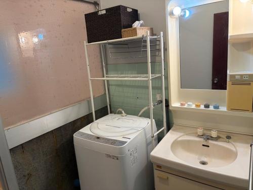 a bathroom with a washing machine and a sink at 麻心家azamiya in Nagao