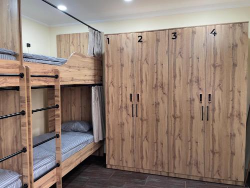 two bunk beds in a room with wooden walls at ATB Grand Hostel in Atyrau