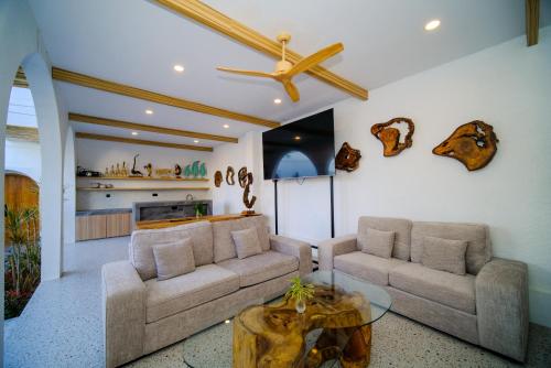 a living room with two couches and a table at Serenity Garden Villas by Danka Hospitality in Hang Nadim International Airport