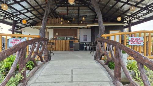 a wooden bridge over a walkway in a building at Beachfront Aircon Kubo for 4pax in Caba