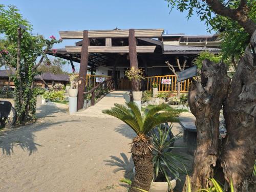 a palm tree in front of a building at Beachfront Aircon Kubo for 4pax in Caba