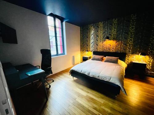 a bedroom with a bed and a desk and a window at Au petit Chapeau Rouge in Clisson