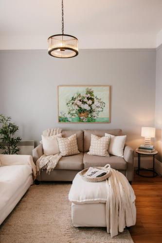 a living room with a couch and a table at Charm on Forster in Invermay