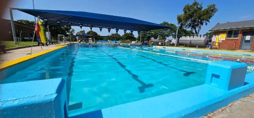 a large blue swimming pool with an umbrella at The Ashford Hotel and Restaurent in Ashford