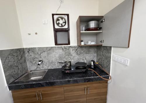 a kitchen with a sink and a stove at Sky Homestay in Noida
