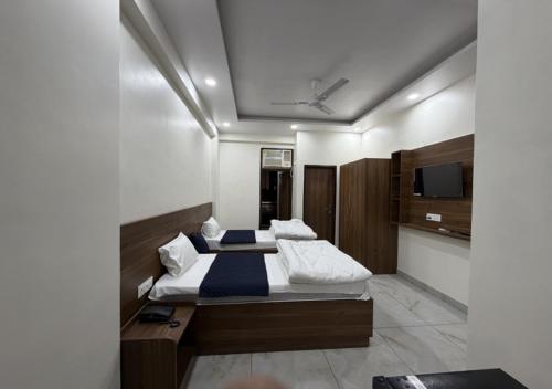 a bedroom with a bed and a tv on the wall at Sky Homestay in Noida