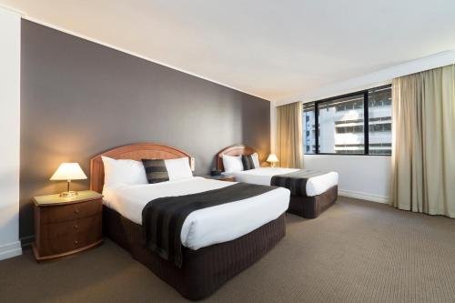 a hotel room with two beds and a window at Great Southern Hotel Brisbane in Brisbane
