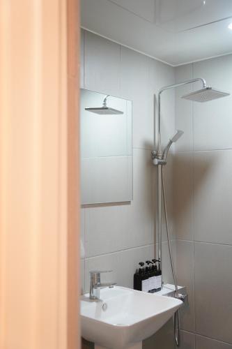 a bathroom with a sink and a mirror at Hotel Azure Incheon in Incheon