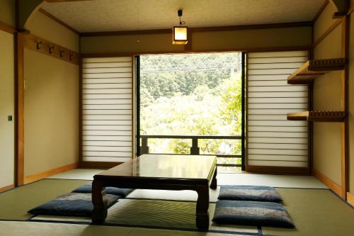 a room with a bench in front of a large window at Irorino Yado Sankichi in Izu