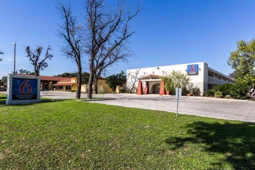 a building with a sign in the grass in front of it at Motel 6-Uvalde, TX in Uvalde