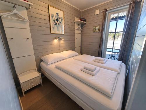 a small bedroom with a white bed and a window at Golsfjellet Apartment with Sauna in Gol