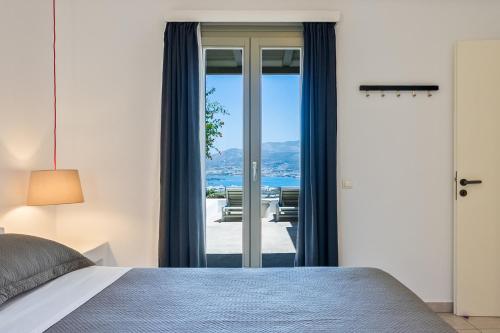 a bedroom with a bed and sliding glass doors at Lagadia Village in Antiparos