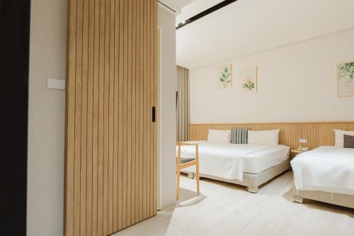 a hotel room with two beds and a table at Feng-Chi Inn in Taitung City