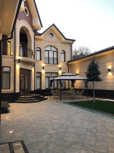 a large building with a patio with tables and benches at Symphony Boutique in Tashkent