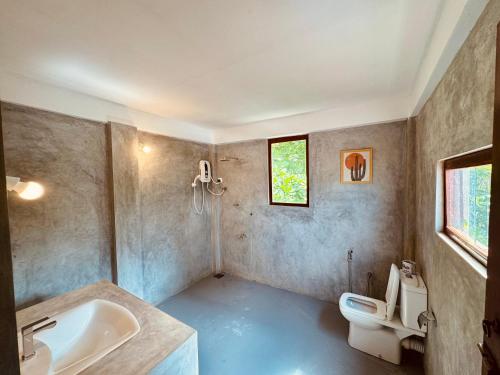 a bathroom with a sink and a toilet at Rupas Hotel in Arugam Bay