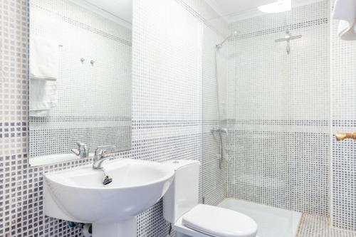 a white bathroom with a sink and a toilet at Calpe Bay Masnou 24 in Calpe