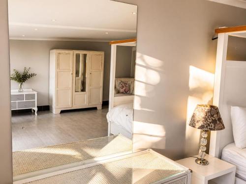a living room with a mirror and a bed at Serenity Stay- Walmer in Gqeberha
