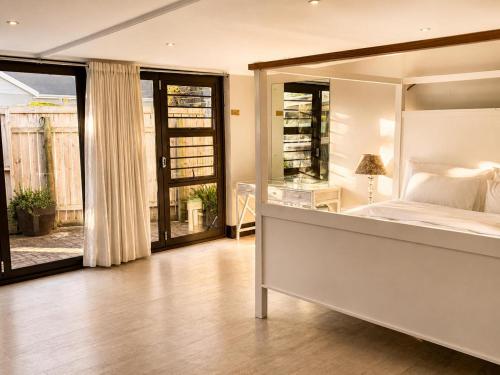 a bedroom with a large bed and a balcony at Serenity Stay- Walmer in Gqeberha