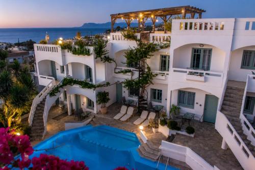 an aerial view of a building with a swimming pool at Kurmulis Studios in Stalos