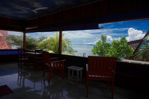 a restaurant with chairs and a view of the ocean at 4 Sisters Divers in Bunaken
