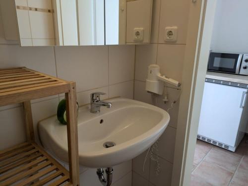 a bathroom with a sink and a microwave at Lutz Appartements Südheide - Einzelzimmer in Gifhorn