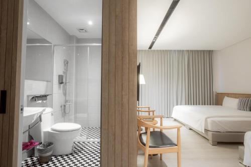 a hotel room with a bed and a bathroom at Feng-Chi Inn in Taitung City