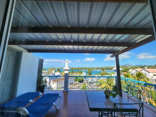 a balcony with blue chairs and a view of the water at Le Dodo Appartements in Trou d'Eau Douce