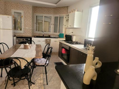 a kitchen with a table and chairs and a counter top at appart kelibia a 10 minutes d une belle plage el fatha in Kelibia