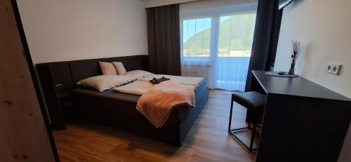 a bedroom with a bed and a desk and a window at Die Sonnenblume in Sankt Kanzian
